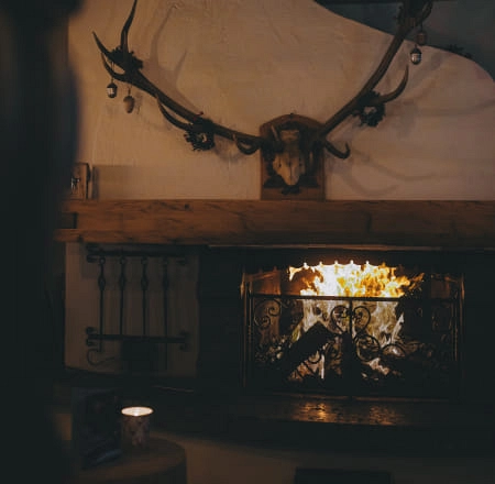 Kamin mit Geweih und brennendem Feuer